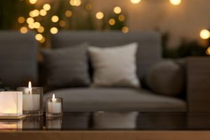 A close-up of a coffee table in a beautiful living room at night featuring a comfortable sofa, indoor plants, lit candles, and glowing lights that create a warm atmosphere. 3d render, 3d illustration